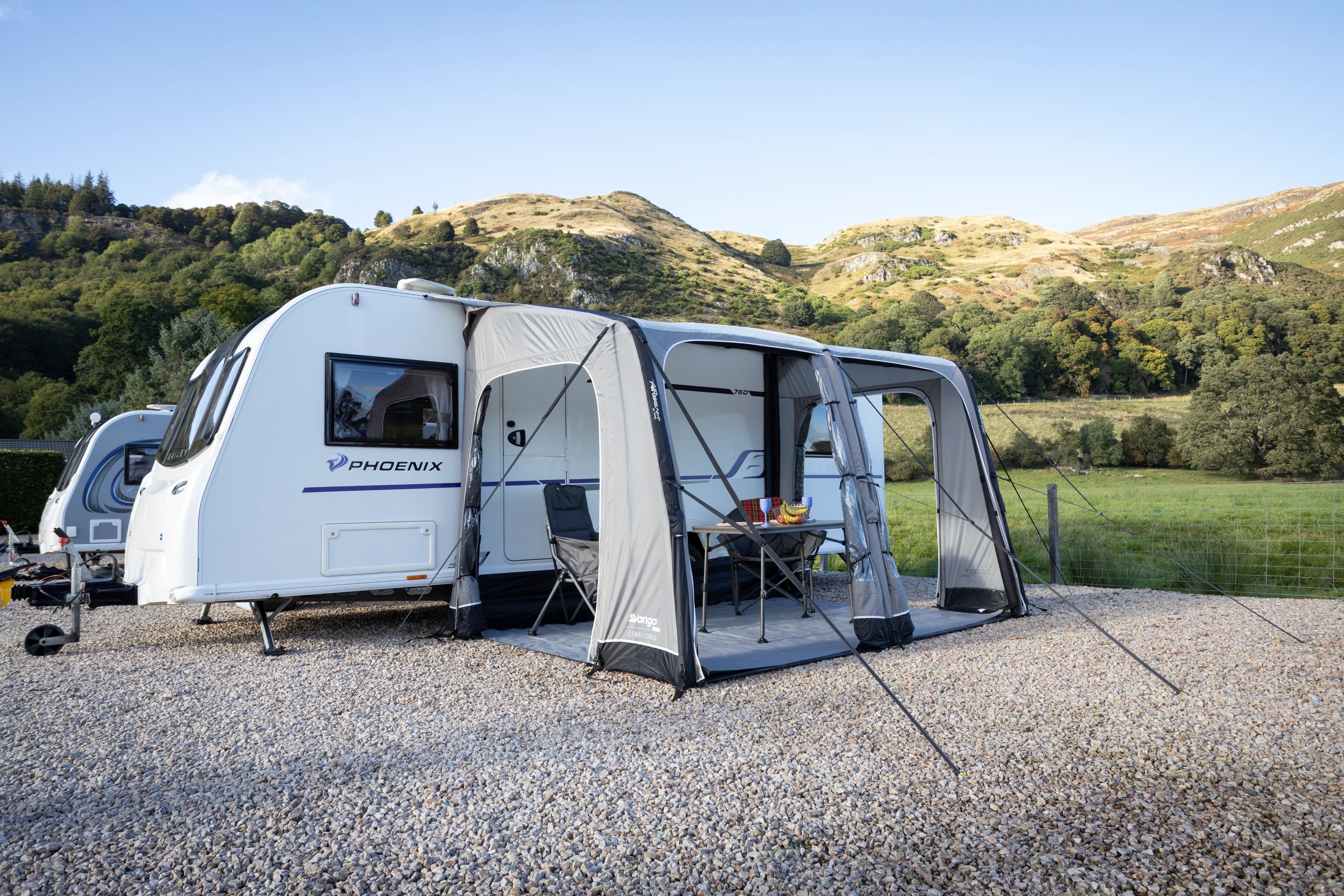 Caravan with an attached awning in a scenic outdoor setting