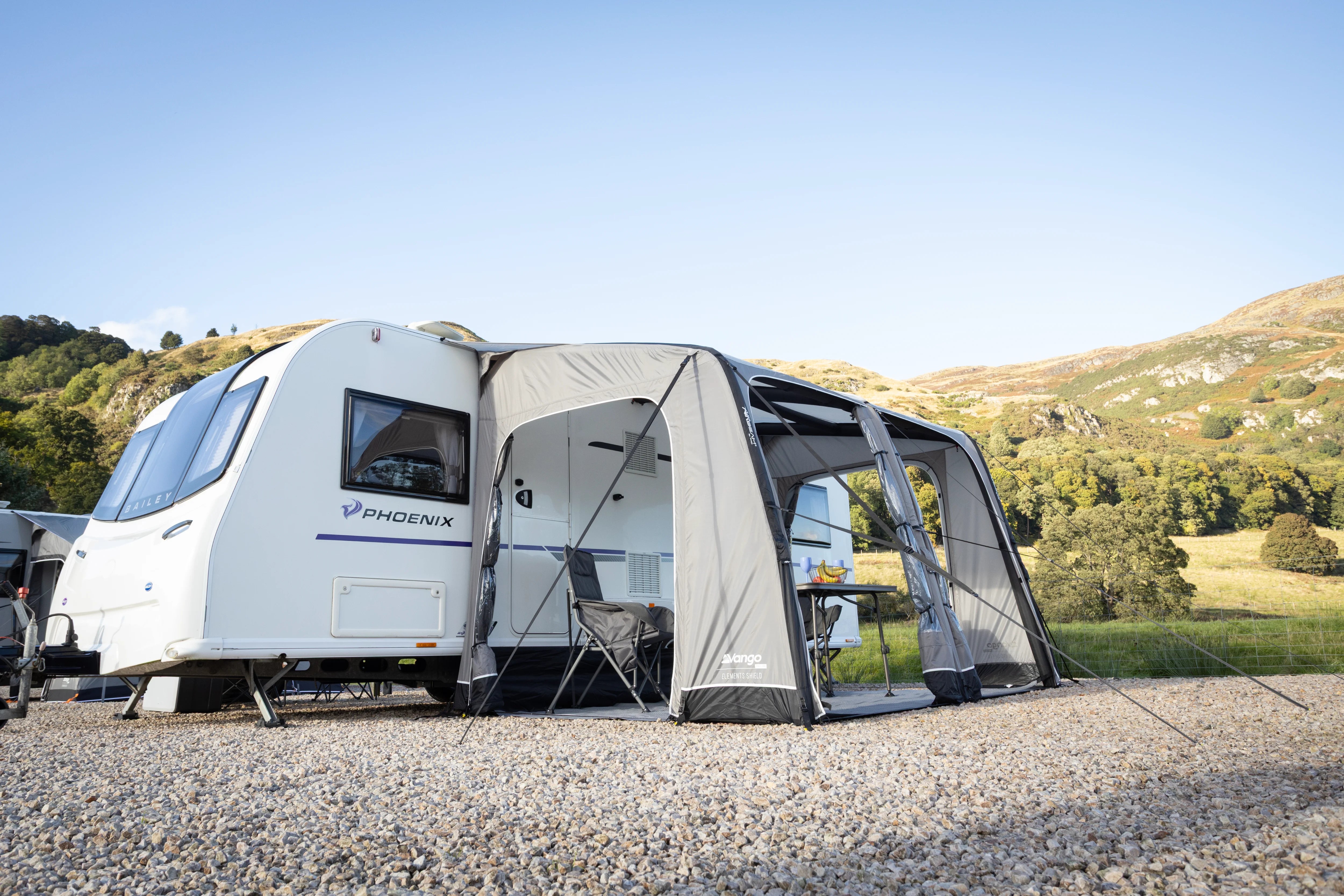 Caravan with an attached awning in a scenic outdoor setting