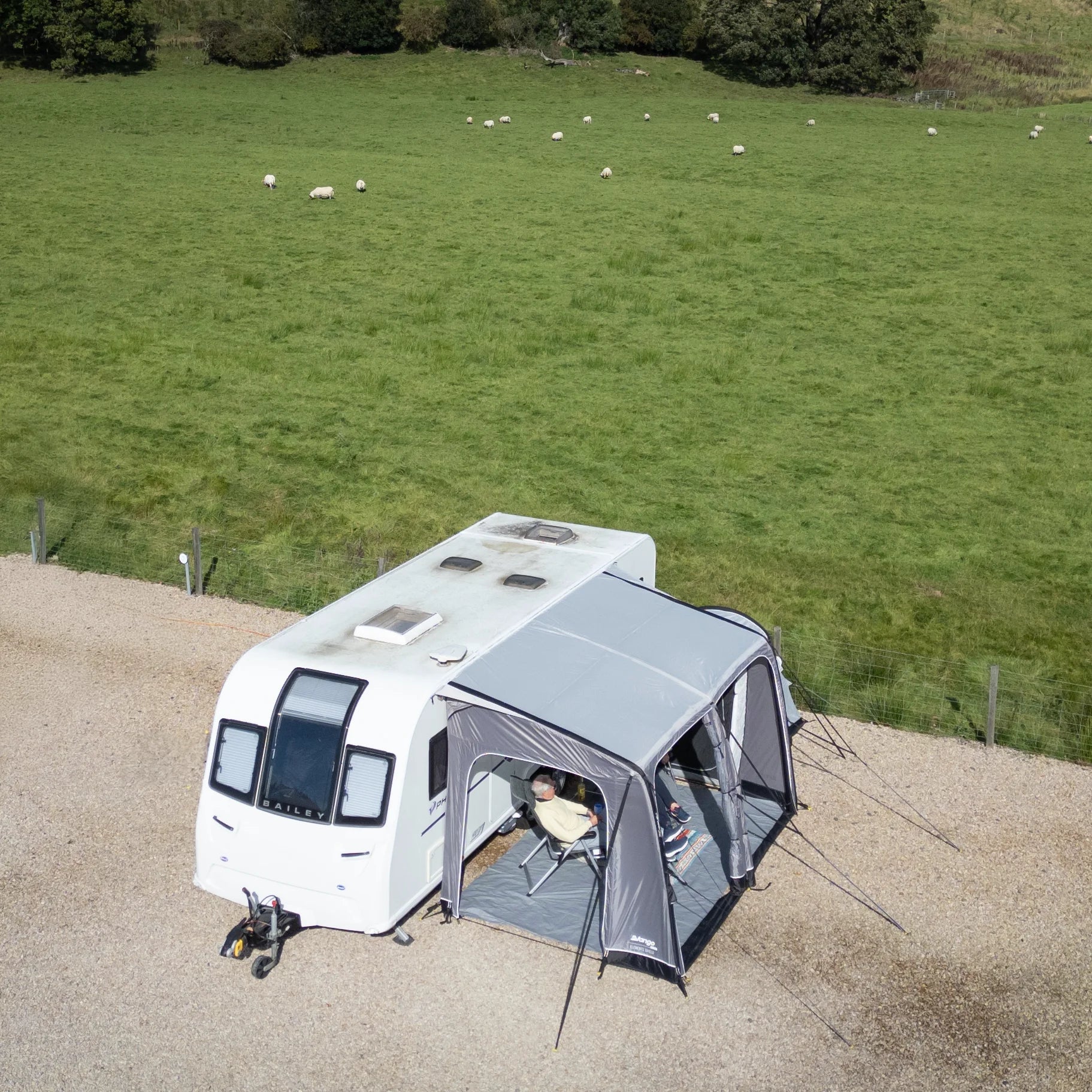 Camper van with an extended awning in a grassy field