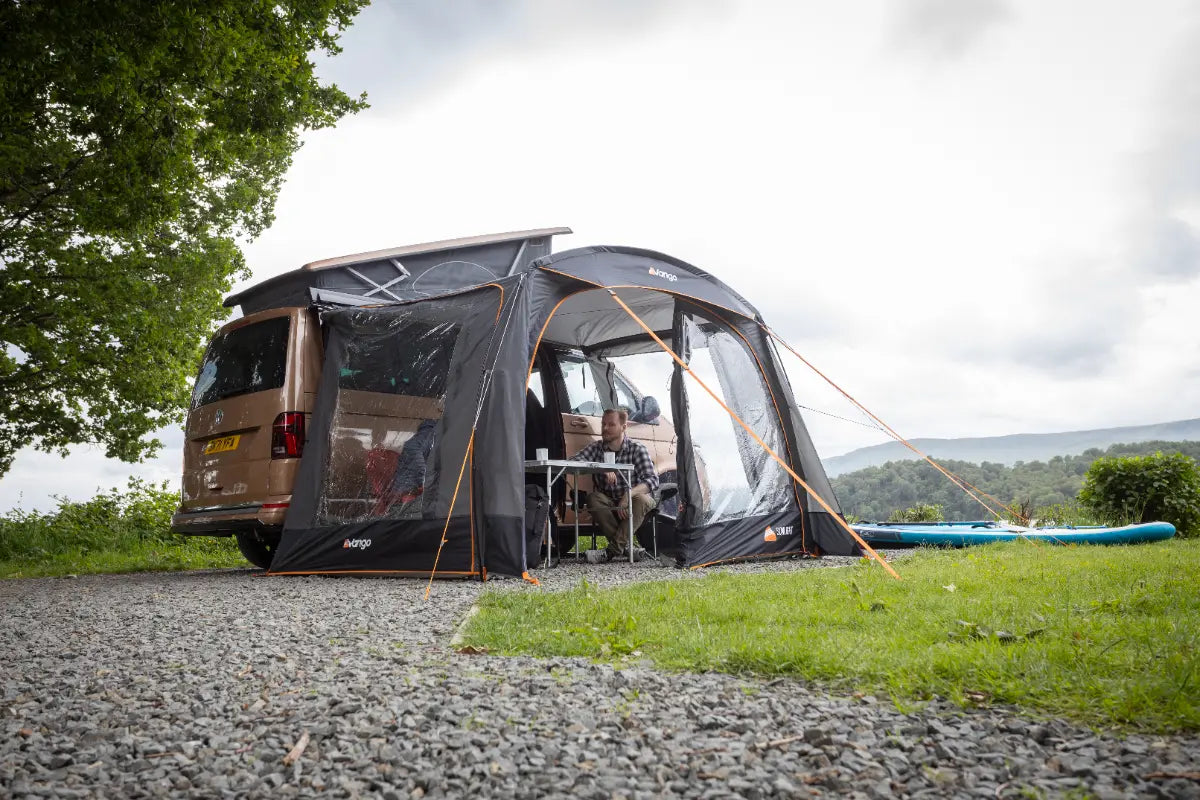 The Vango Sunlight Poled Awning/Canopy set up, attached to a van in a scenic location.